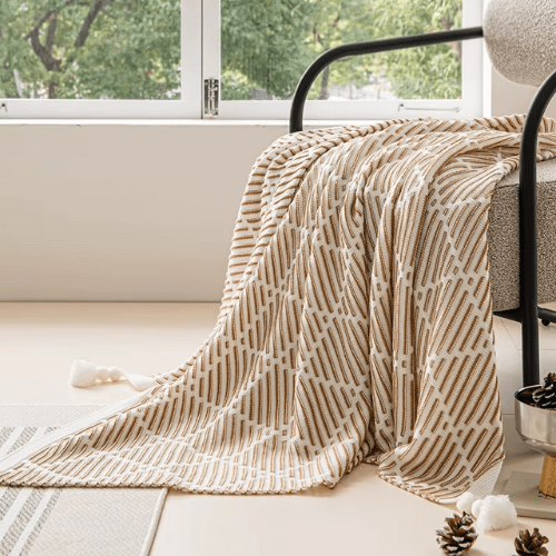plaid décoratif à pompon marron sur une chaise