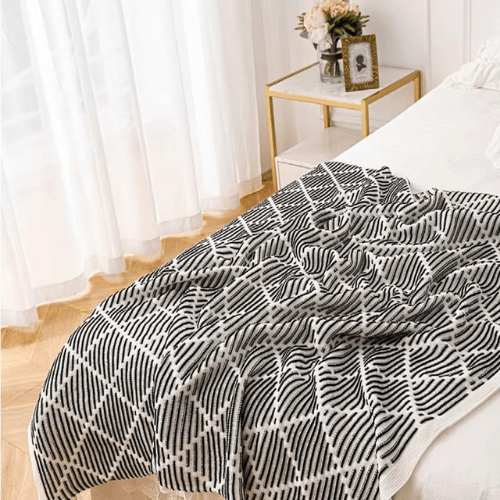 plaid décoratif à pompon placer au pieds du lit