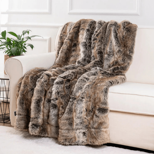 plaid fausse fourrure doulux poser sur un canapé blanc
