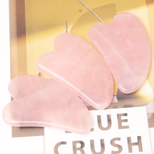 gua sha quartz rose sur une table