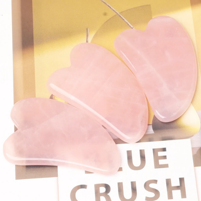 gua sha quartz rose sur une table