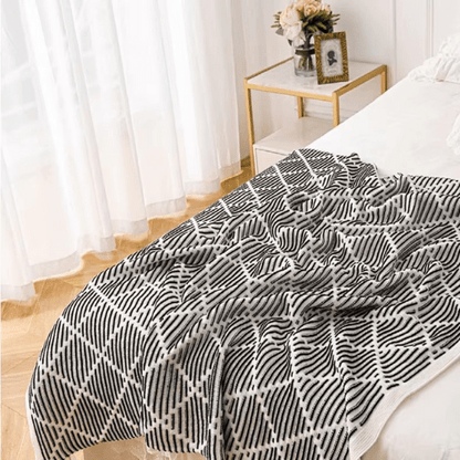 plaid décoratif à pompon placer au pieds du lit
