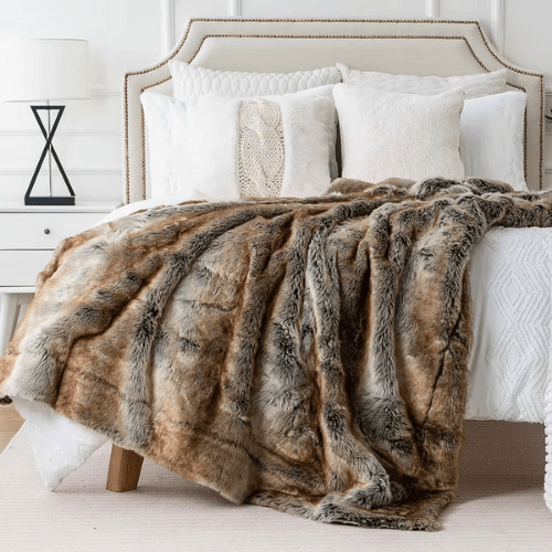 plaid fausse fourrure doulux placer sur un lit blanc